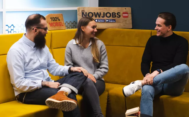 Twee mannen en één vrouw die een gesprek hebben in een zetel