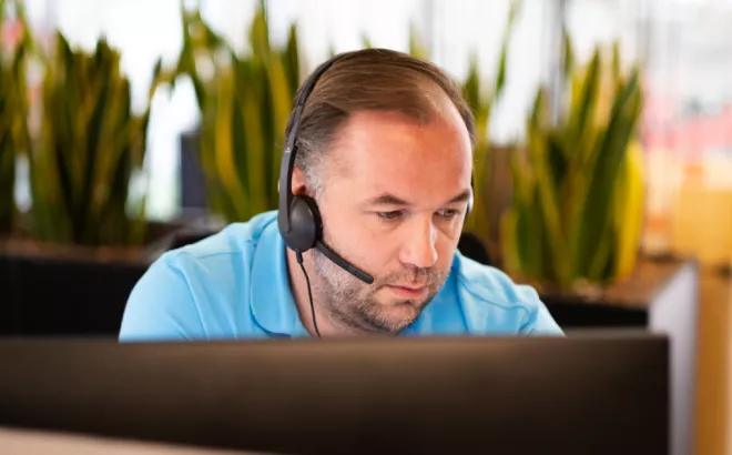 Een man met een headset op in een kantoor